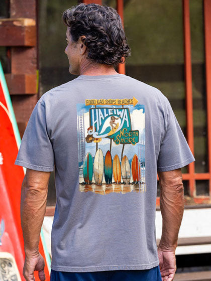 Man wearing a Crater dyed t-shirt with a graphic design on the back, standing in front of a red vehicle.
