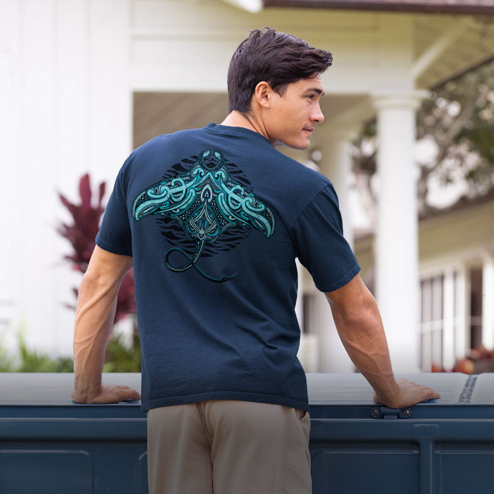Man wearing a navy blue t-shirt with a green graphic on the back, standing outdoors.