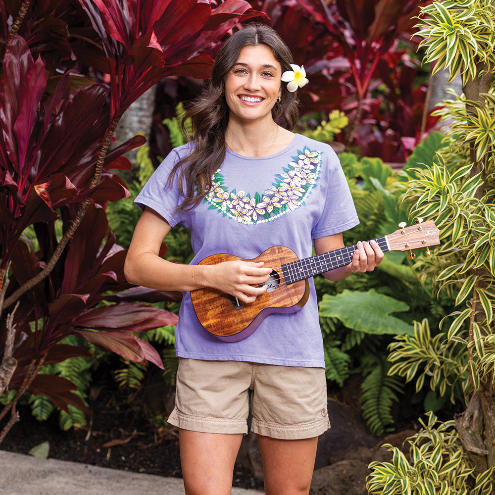 Woman playing a ukulele in a garden setting