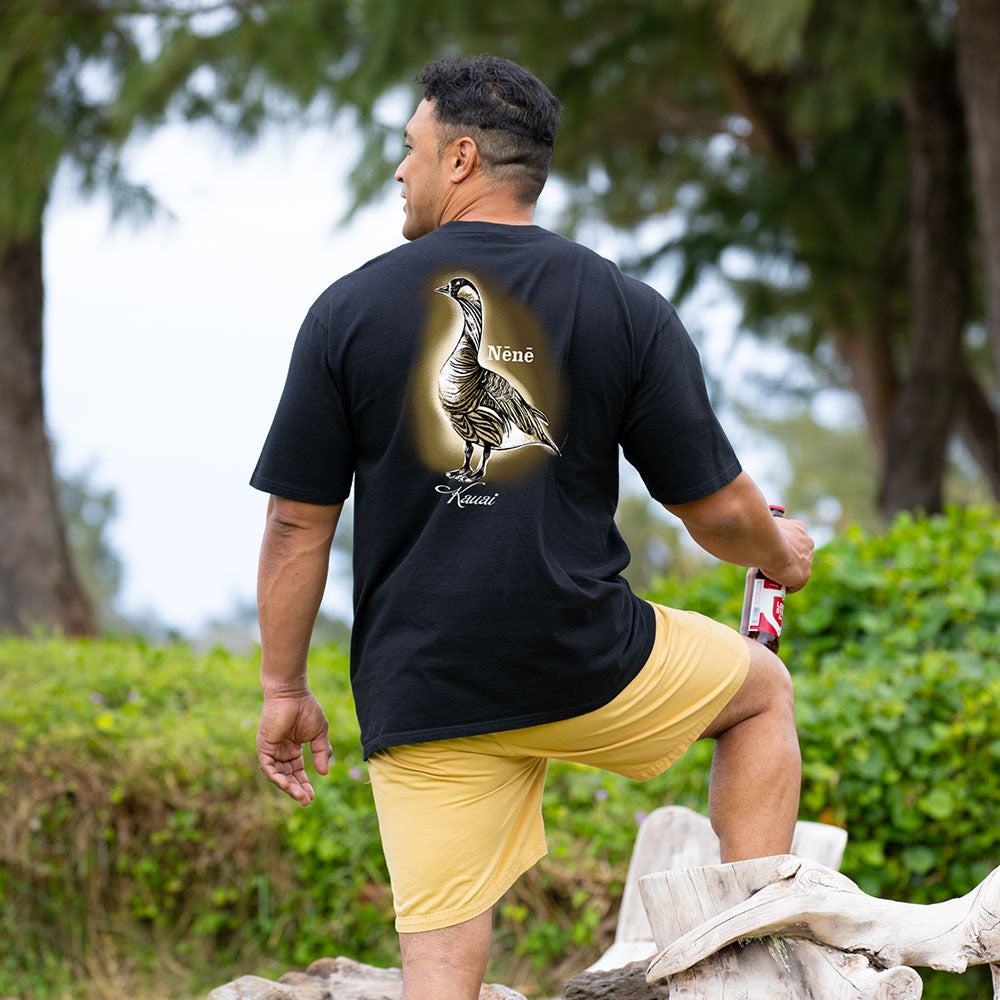 Man wearing a black t-shirt with a bird design outdoors