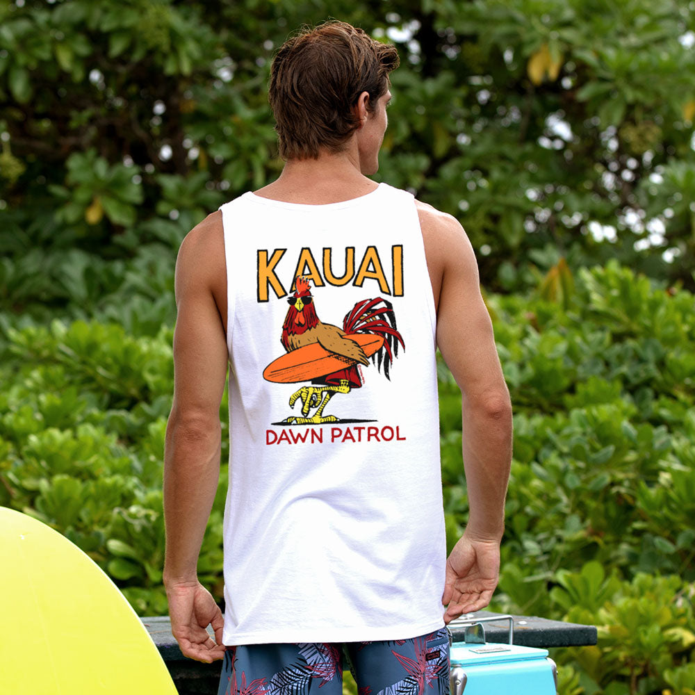 Person wearing a white tank top with 'Kauai Dawn Patrol' design in a natural setting
