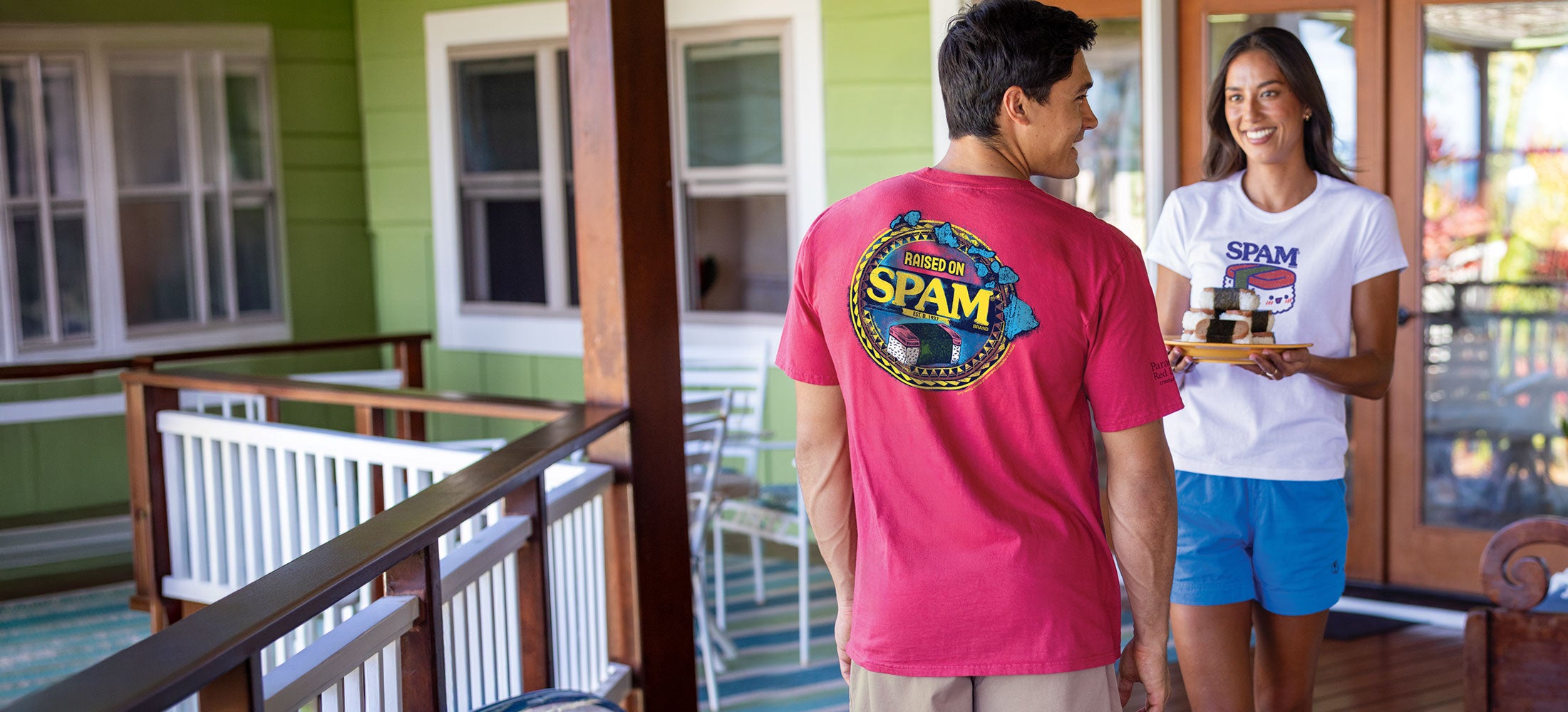 Two people on a porch with one wearing a pink 'SPAM' t-shirt.